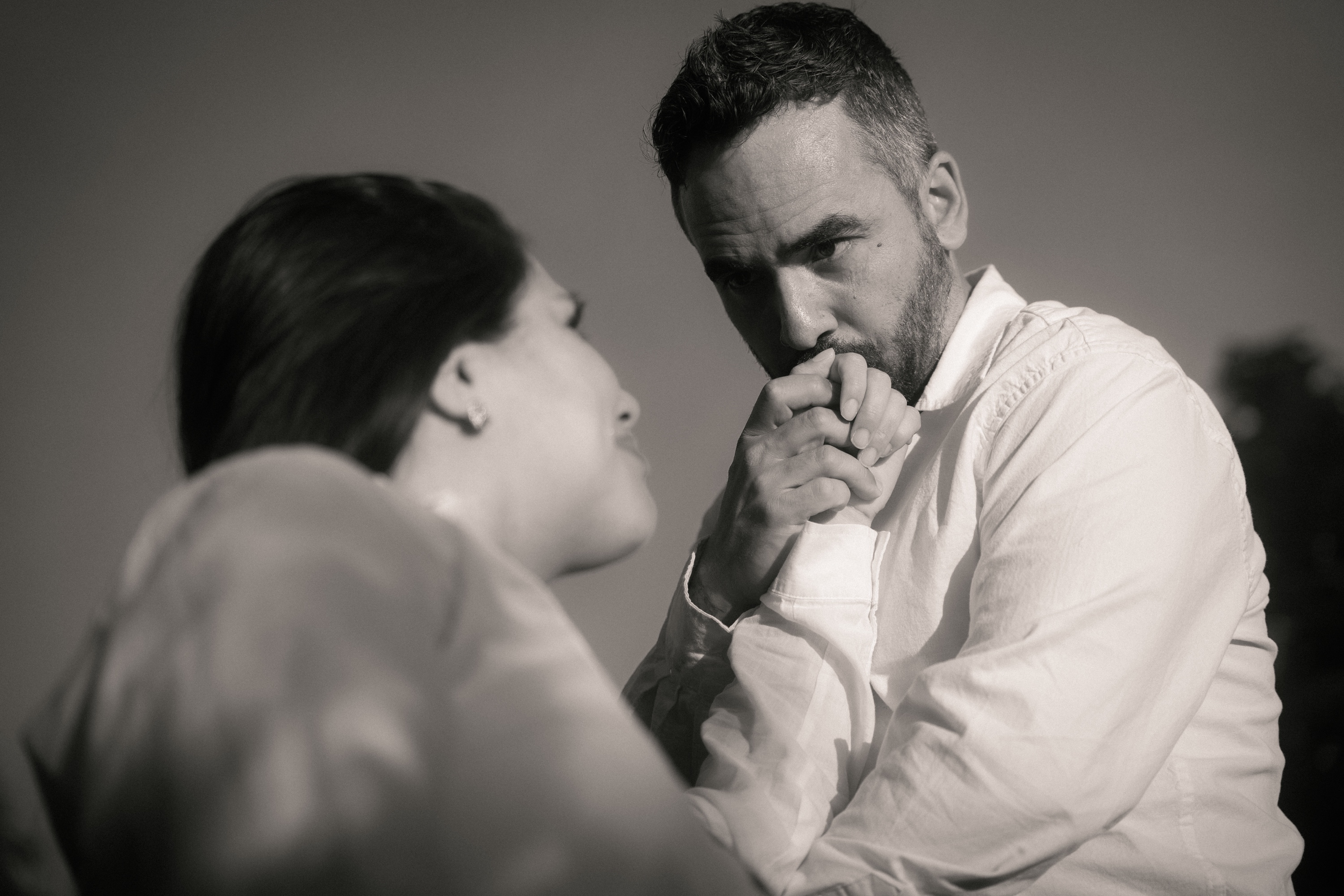 Black and white portrait of a man kissing his partner's hand