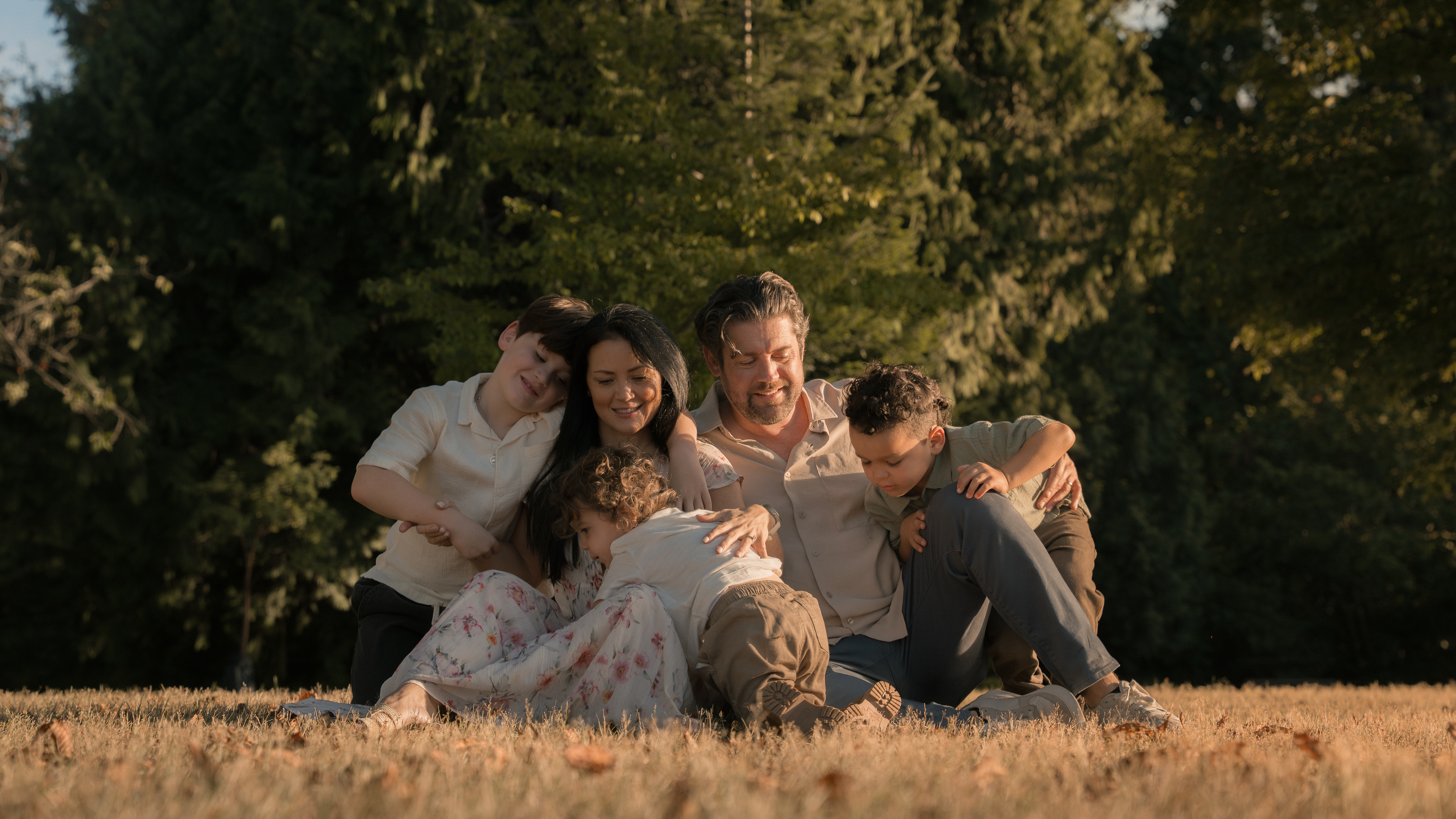 A family leaning closely together in a field