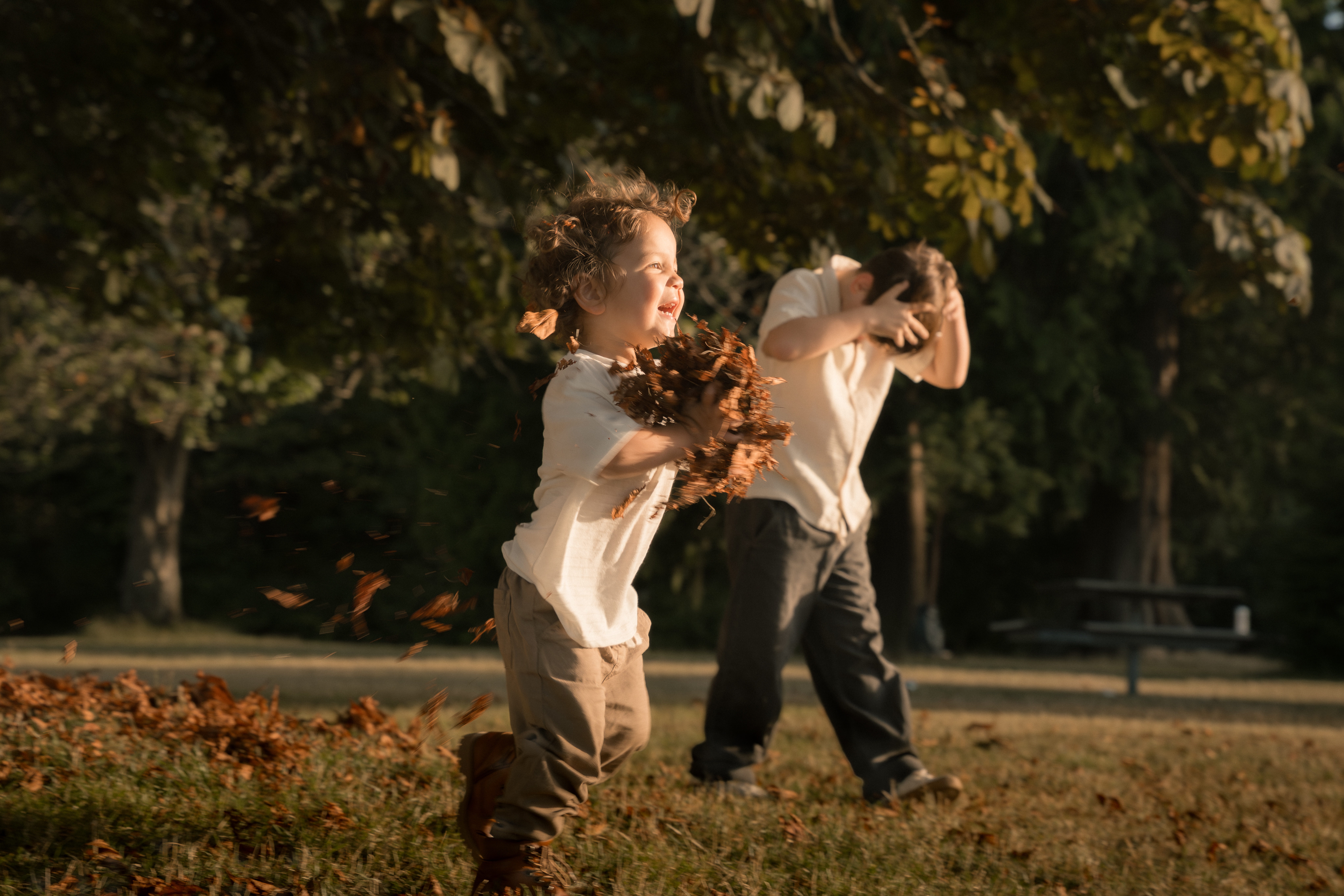 A laughing child running through a shower of autumn leaves