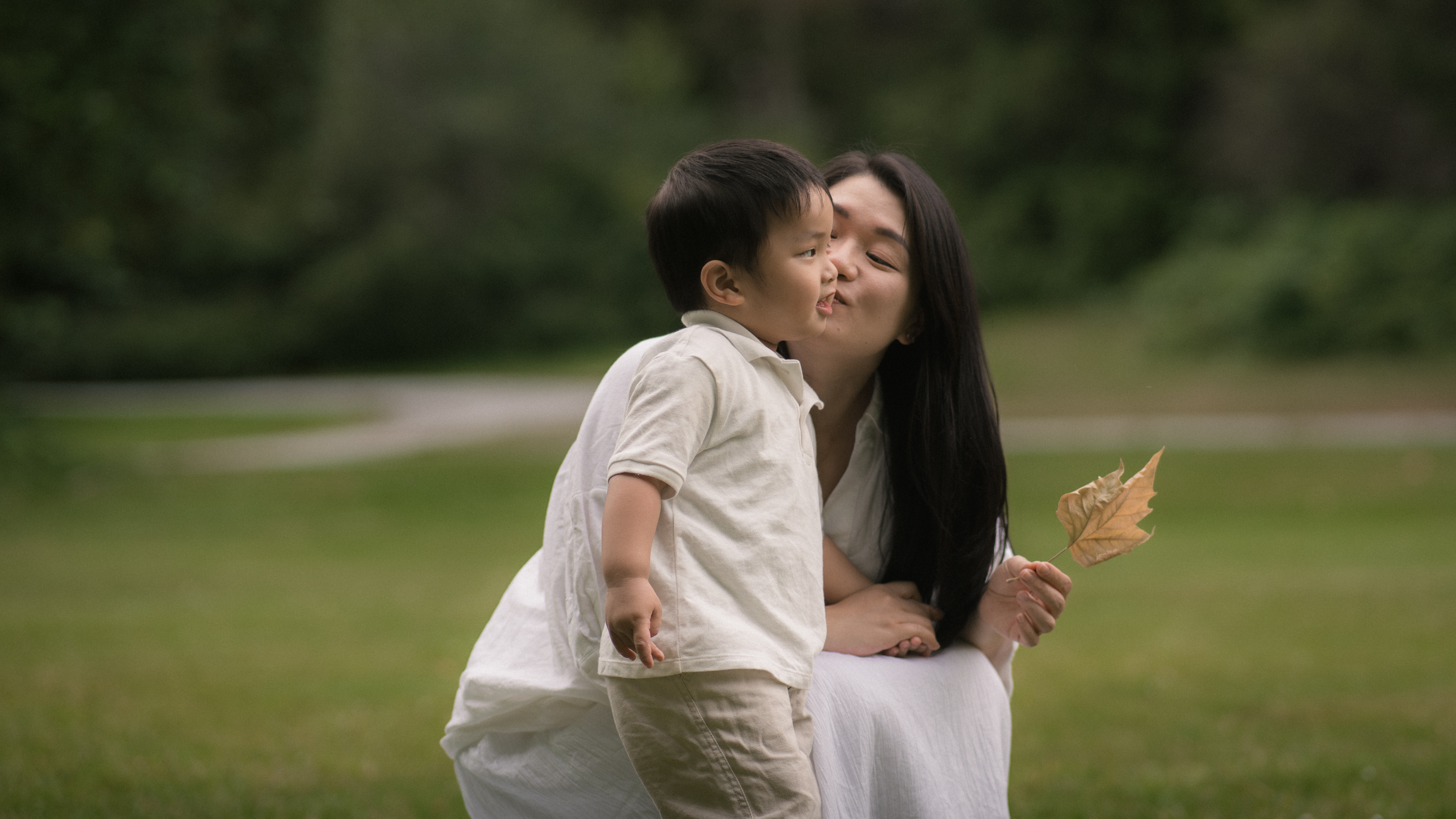 A mother and child held within a layered family moment