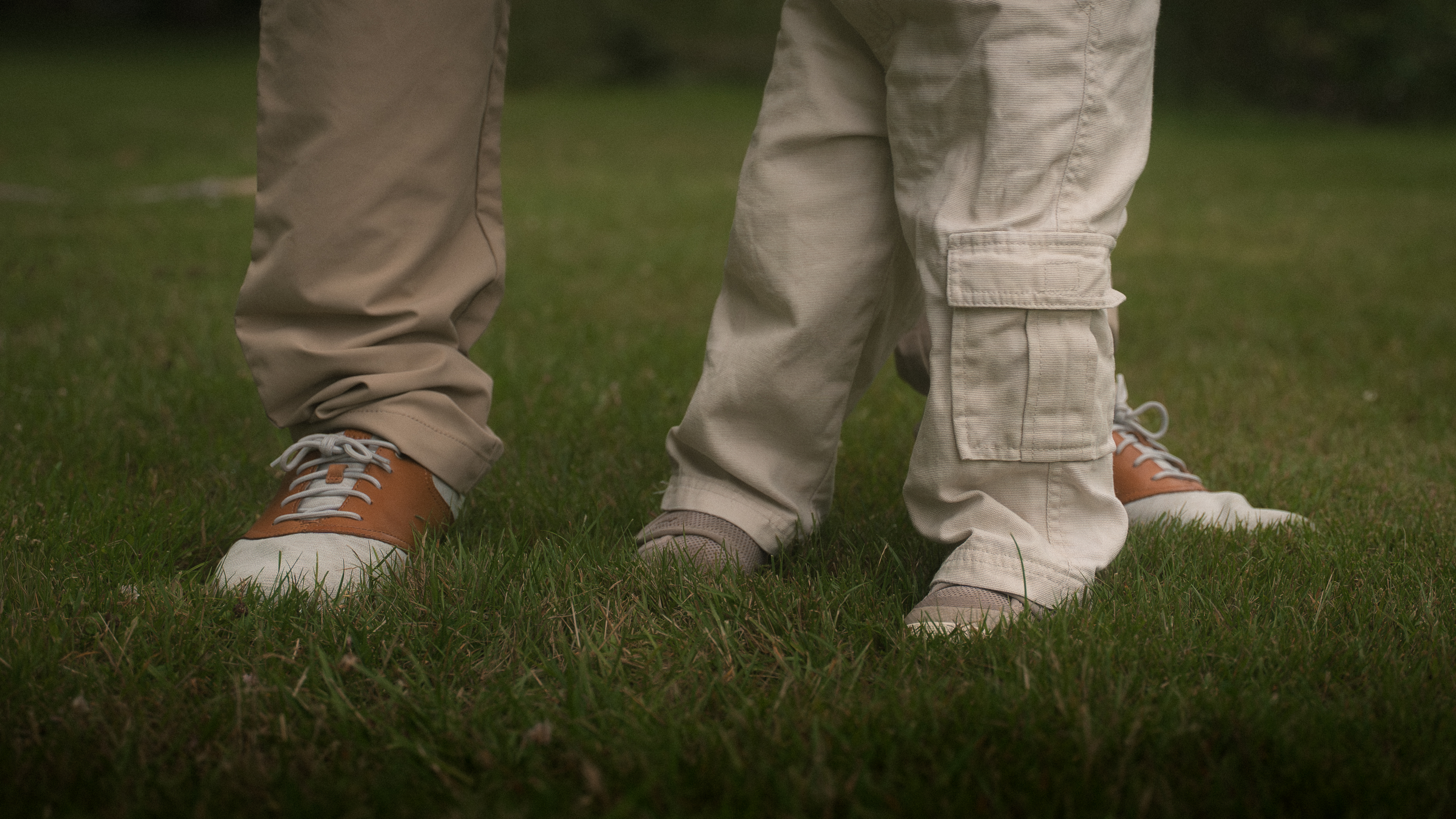 A young child reaching up toward the welcoming hands of their family